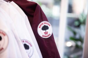 Close-up image of a maroon jacket with a "South College Nursing" patch featuring a tree and the text "Since 1882" on the sleeve.