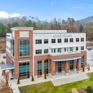 A four-story building with "South College" written on the front. The structure features a combination of brick and white facade with large blue-tinted windows.